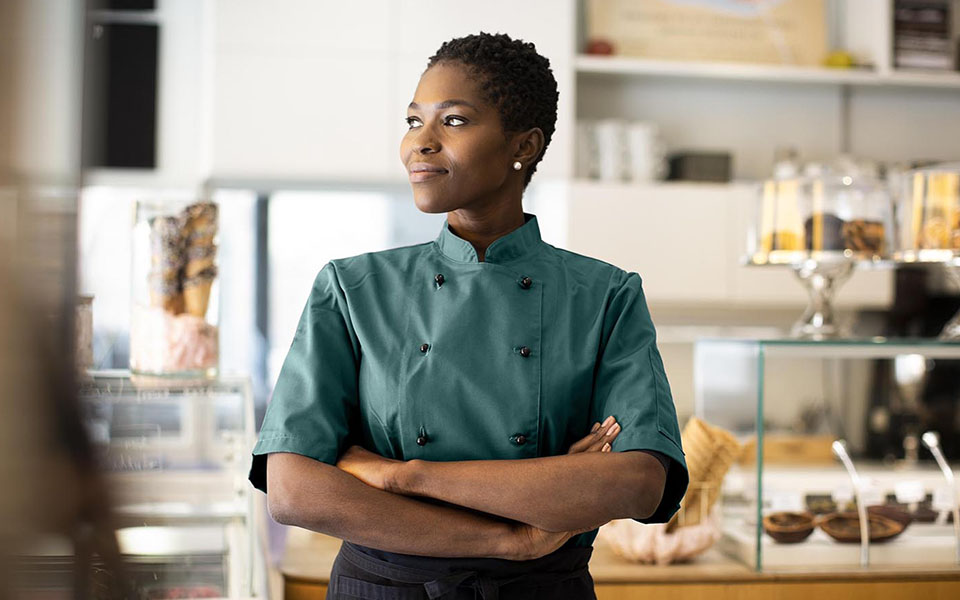 person in bakery looking to the left and smiling