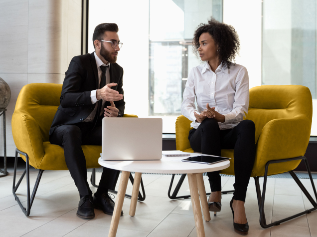  A man and woman are in the middle of a discussion in an office.