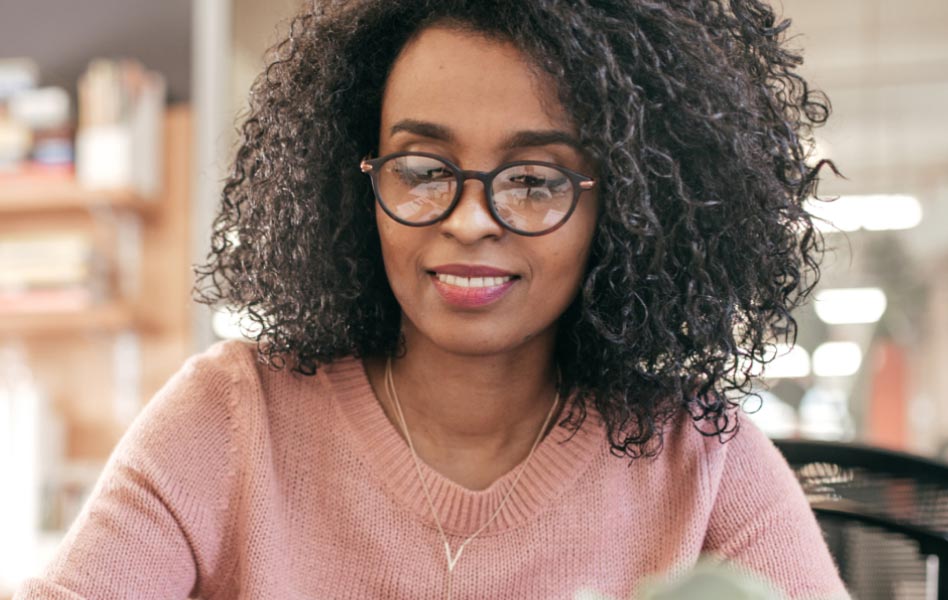 A young woman is sitting at a desk.