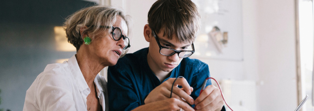 A middle-aged woman helping a young guy do something