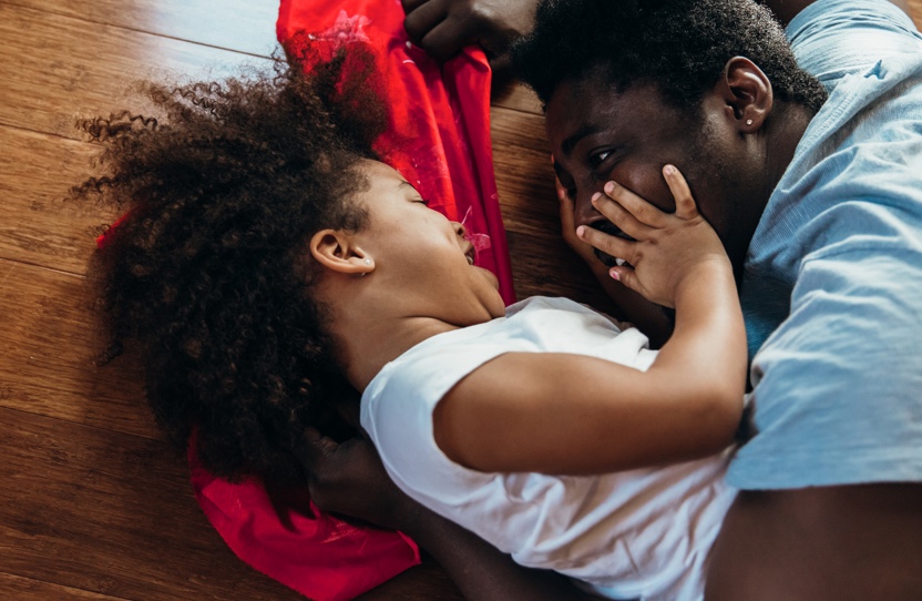 A girl is touching her father’s face.