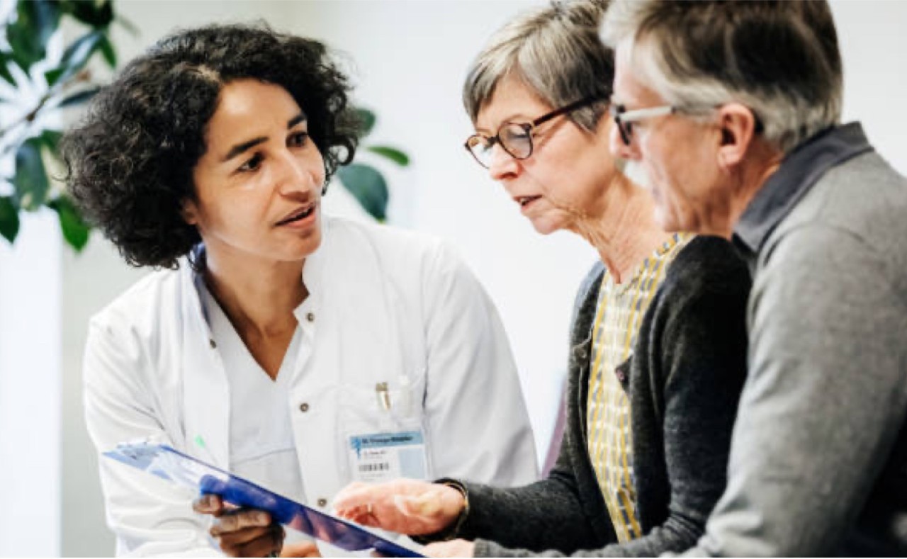 Healthcare professional discussing a document with an elderly couple
