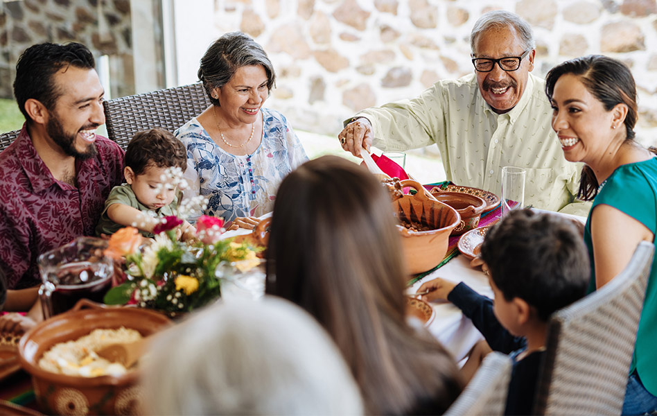 A multigenerational family enjoys a meal together.