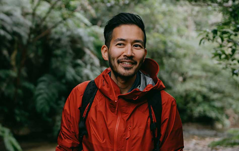 Man hiking in a park surrounded by beautiful trees and plants.