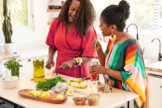 Two women preparing food together in the kitchen.