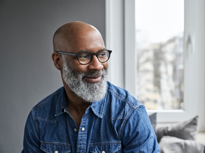A man smiles as he looks off to the side.