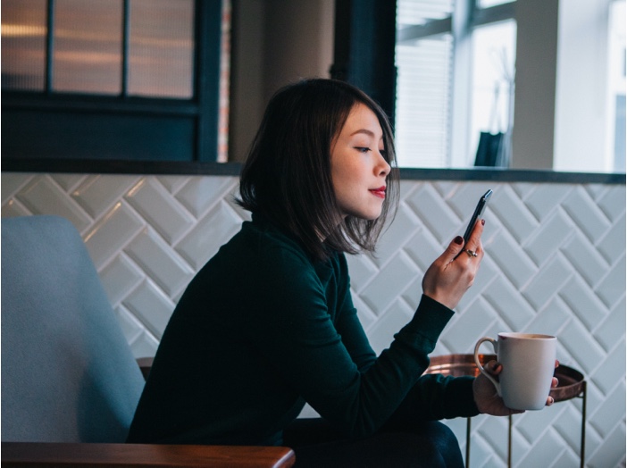 A woman checks her phone.
