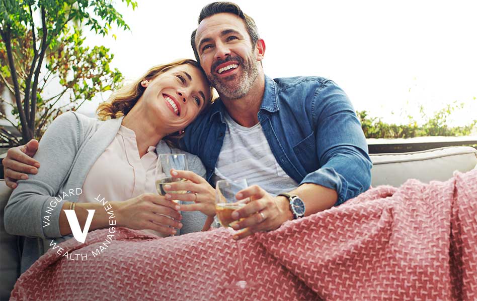  A couple sits together outside drinking wine.