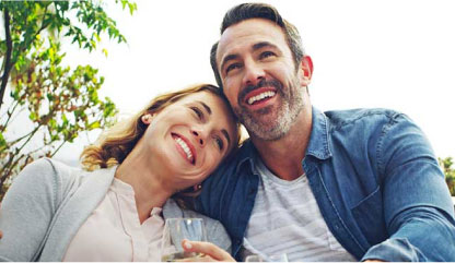 Man and woman laughing while drinking wine.