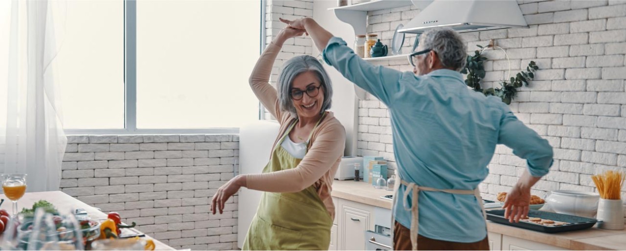 Man and woman dancing in their kitchen.
