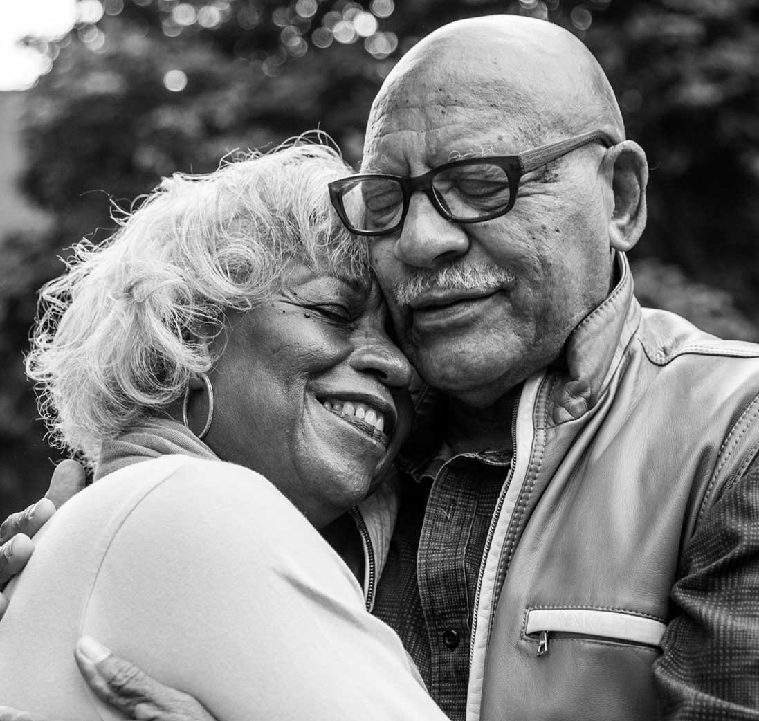 Image of happy, older couple hugging with eyes closed
